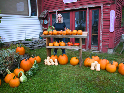 Diane standing next to a pumpkin and gourd stand outside of the Golding addition